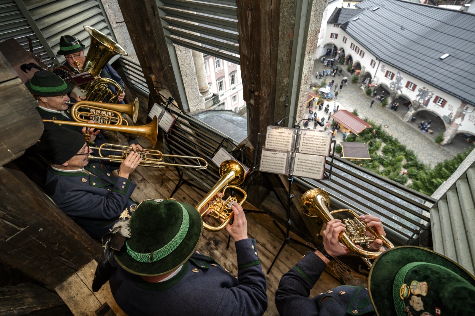 Turmbläser in Tracht musizieren hoch über dem winterlichen Marktplatz von Berchtesgaden
