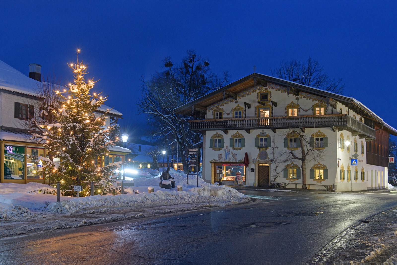 Winterliche Ortsansicht von Oberaudorf zur blauen Stunde mit beleuchtetem Lüftlmalerei-Haus und Christbaum