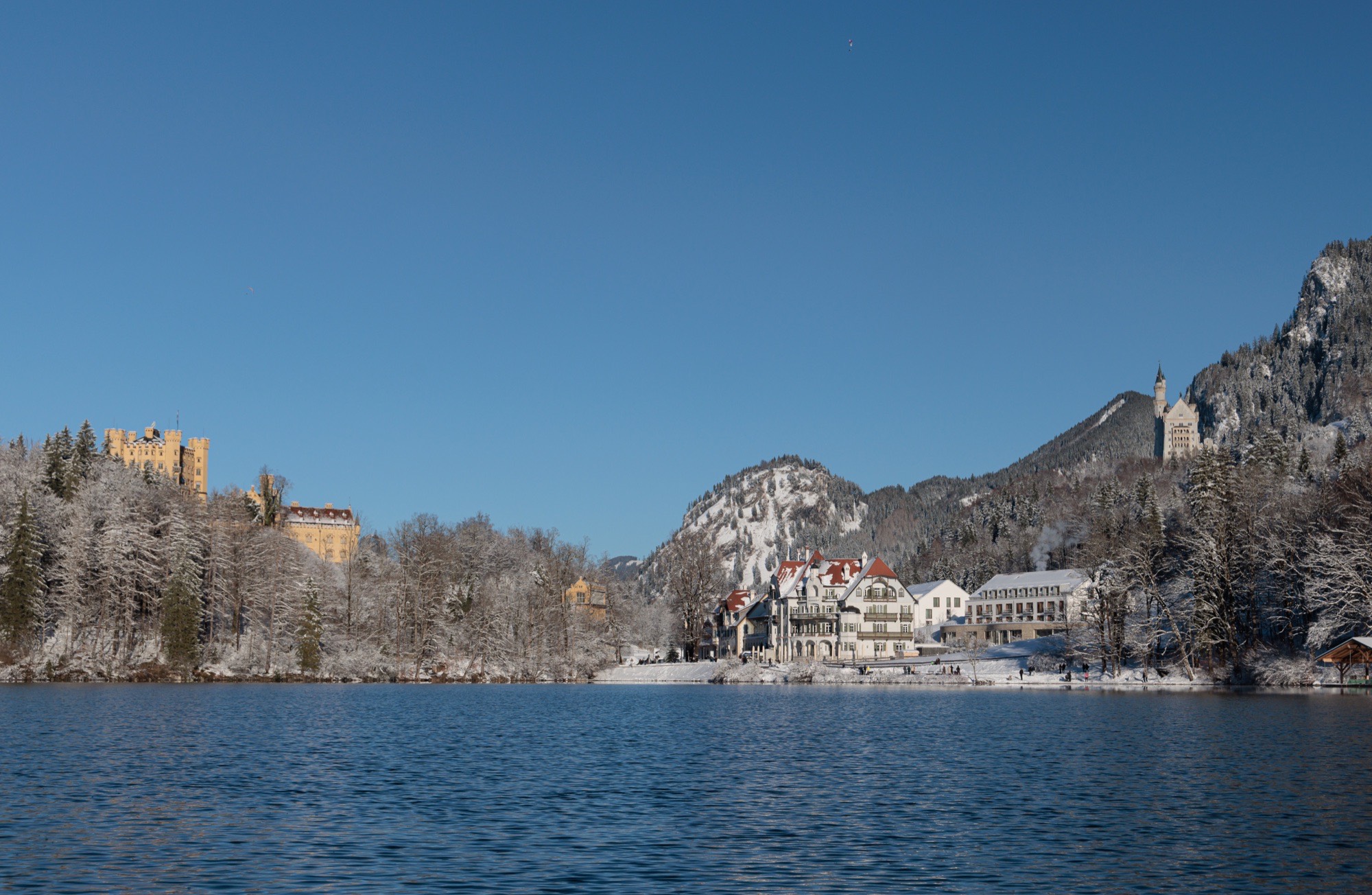 AMERON Neuschwanstein am verschneiten Ufer des Alpsees, links Schloss Hohenschwangau, rechts Schloss Neuschwanstein